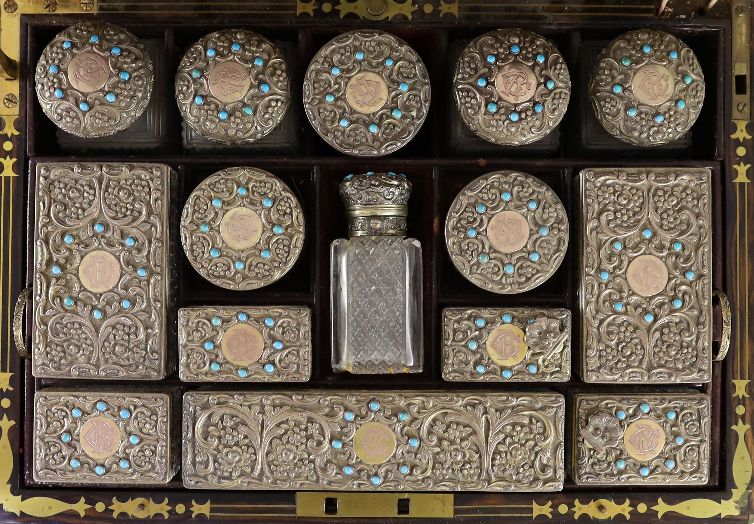 A good Victorian brass mounted and brass monogrammed coromandel travelling toilet set, containing fifteen silver gilt and turquoise bead mounted glass jars and bottles, by Hallstaff & Hannaford